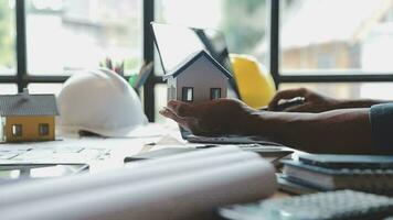 Image of team engineer checks construction blueprints on new project with engineering tools at desk in office. video