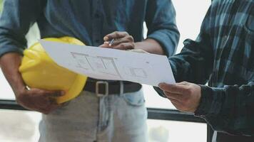 Image of team engineer checks construction blueprints on new project with engineering tools at desk in office. video