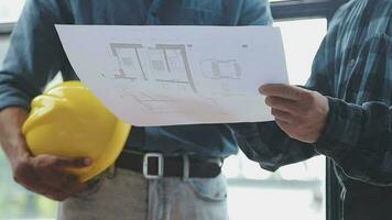 Image of team engineer checks construction blueprints on new project with engineering tools at desk in office. video