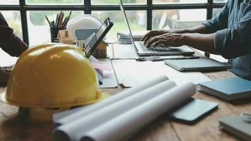 Image of team engineer checks construction blueprints on new project with engineering tools at desk in office. video