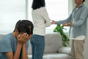 problema en familia. hija utilizar manos cubrir tu cara y sensación estresado desde el padres disputa. niño es tener mental problema. peleas, violencia, depresión, suicidio, desánimo, social problema foto