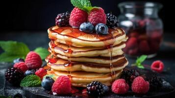 Stack of pancakes with fresh blueberry, raspberry and blackberry on brown plate photo