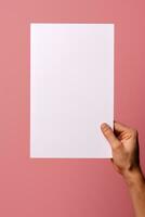 A human hand holding a blank sheet of white paper or card isolated on pink background. ai generated photo