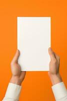 A human hand holding a blank sheet of white paper or card isolated on orange background. ai generated photo