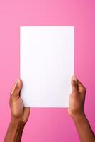 A human hand holding a blank sheet of white paper or card isolated on pink background. ai generated photo