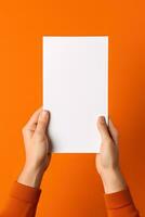 A human hand holding a blank sheet of white paper or card isolated on orange background. ai generated photo