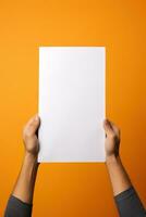 A human hand holding a blank sheet of white paper or card isolated on orange background. ai generated photo