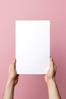 A human hand holding a blank sheet of white paper or card isolated on pink background. ai generated photo