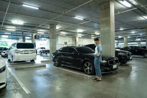 Lost car concept, Stressed woman holding car keys in her hands where her car was stolen leaving only empty space photo