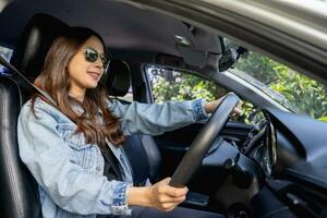 contento asiático mujer en un coche. un hermosa mujer sonrió en su nuevo coche. coche seguro foto