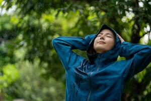 Enjoying the rainy weather. a young woman standing in the rain. photo