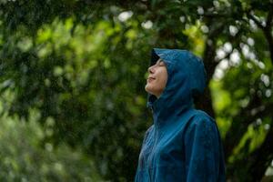 Happy woman standing in rain.  Rainy season. photo