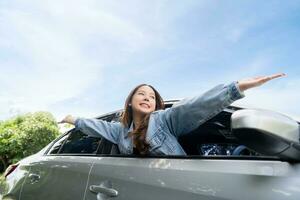 Young beautiful asian women getting new car. She relaxing out of window in a car - Freedom car travel concept photo