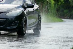 Car splashes through large puddle on flooded street. Motion car photo