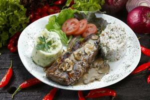 Beef steak with potatoes and rice in isolated white background photo