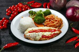 parmigiana filete con pasta, arroz y vegetales foto