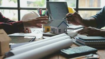 Image of team engineer checks construction blueprints on new project with engineering tools at desk in office. video