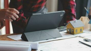 Image of team engineer checks construction blueprints on new project with engineering tools at desk in office. video