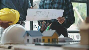 Image of team engineer checks construction blueprints on new project with engineering tools at desk in office. video