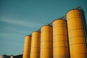 amarillo acero silos antecedentes y textura, metal silos para hormigón mezcla proceso planta. ai generado foto