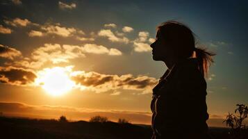 Silhouette of a tired and stressed woman against the sky, sun photo