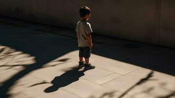 chico y su sombra. solitario pequeño niño jugando con su sombra afuera. imaginario amigo. el concepto de autismo y soledad foto