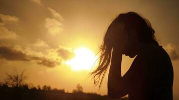 Silhouette of a tired and stressed woman against the sky, sun photo