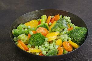 Vibrant frozen veggies in a frying pan Carrots, broccoli, green peas sizzle with potential photo