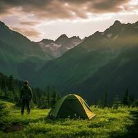 man standing in front of tent in the mountains photo