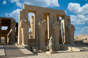 the statues of egyptian gods are in front of a large building photo