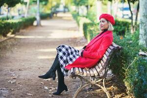 elegante mujer en banco en otoño parque foto