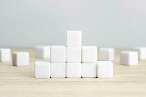 Pyramid of blank white cube blocks on table. Template mockup photo