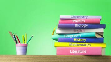School colourfull textbooks on the table. Basic school subjects mathematics, literature, physic,s chemistry and pencils pens in a glass photo