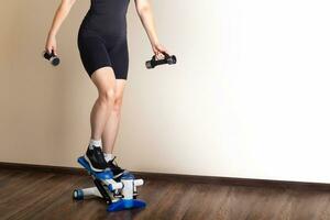 Home fitness. A woman training on a stepper at home. photo