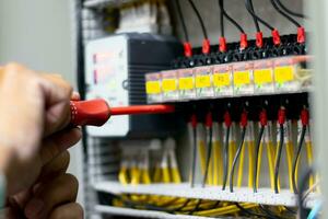 electricista trabajo ensayador medición voltaje y Actual de poder eléctrico línea en eléctrico gabinete control, profesional hombre usos herramienta puesta en marcha prueba o comprobación circuito para proteccion sistema. foto