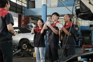 masculino profesional supervisor ingeniero y mecánico trabajadores son alegre con terminado reparar trabajar, trabajo en equipo logros a coche Servicio cochera, y armonioso mantenimiento trabajos en automotor industria. foto