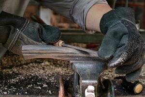 Hand craftsman uses rasp decorate to polish the handle wood hammer handle photo