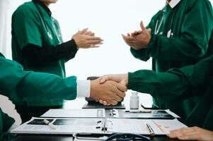 Doctor handshake and partnership in healthcare, medicine or trust for collaboration, unity or support.Team of medical experts shaking hands in teamwork for or success in clinic or hospital photo