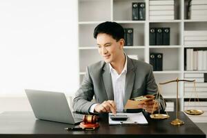 justice and law concept.businessman or lawyer or accountant working on accounts using a smart phone laptop digital tablet calculator and documents in modern office photo
