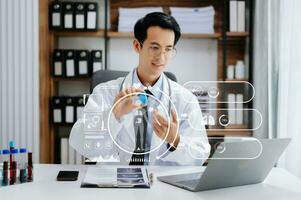 medical technology concept,smart Asian doctor hand working with modern laptop computer with his team virtual icon diagram. in hospital photo