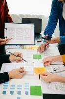 UX developer and ui designer brainstorming about mobile app interface wireframe design with customer breif and color code at office. photo