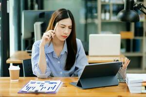 Businesswoman working in the office with working notepad, tablet and laptop documents photo