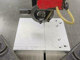 The band saw is cutting stainless steel plates photo