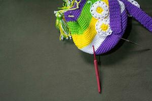 Crochet accessories with koche, using multi-colored threads, handicrafts, on green velvet. photo