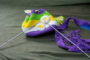 Crochet accessories with koche, using multi-colored threads, handicrafts, on green velvet. photo