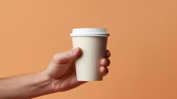 a person holding a coffee cup in their hand close up. photo