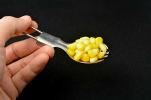 boiled corn kernels black background photo