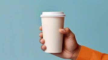 a person holding a coffee cup in their hand close up. photo