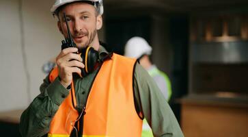 Architect caucasian man and woman working with colleagues mixed race in the construction site. Architecture engineering on big project. Building in construction process interior. photo