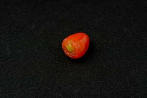 grape tomatoes. Black background with bite marks photo